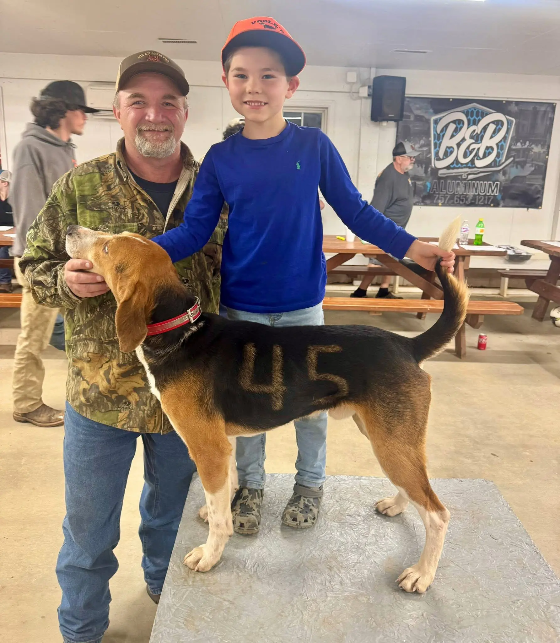 Man and boy with numbered hunting dog.