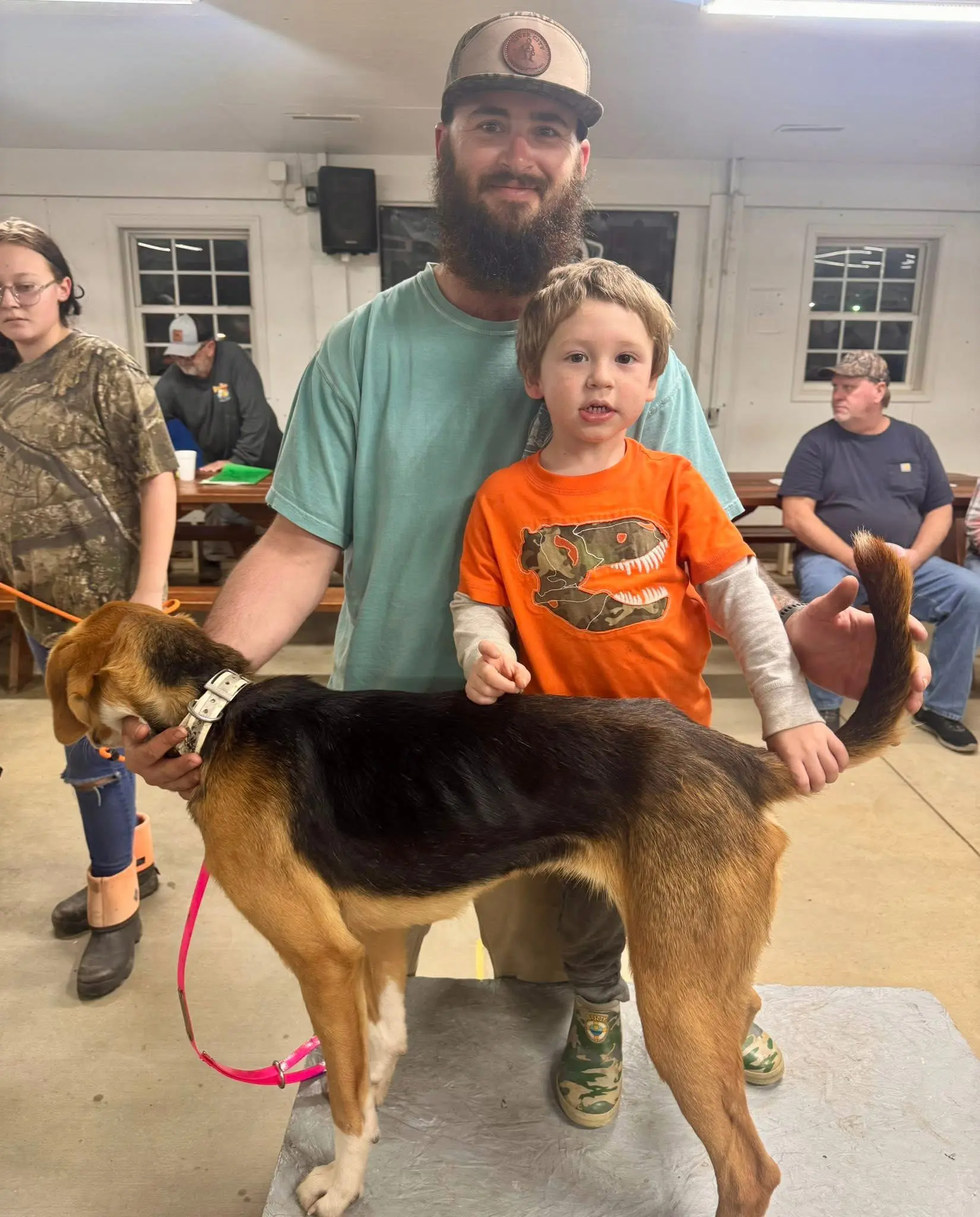 Man and child with a dog indoors.