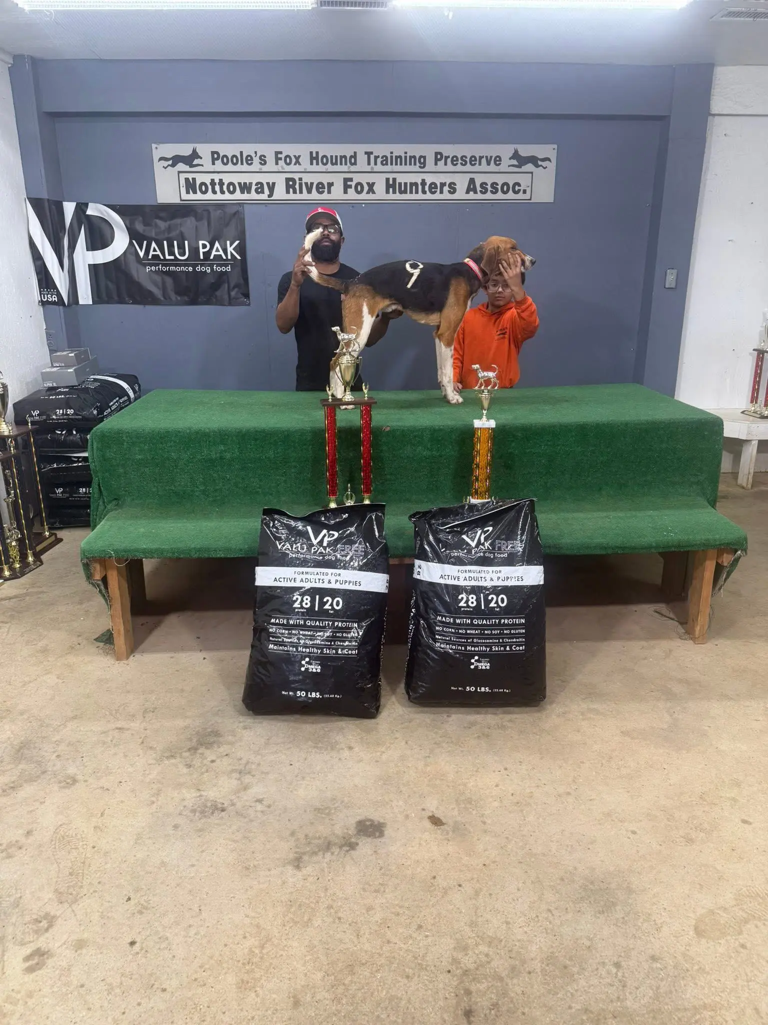 Dog show winners with trophies and prizes.