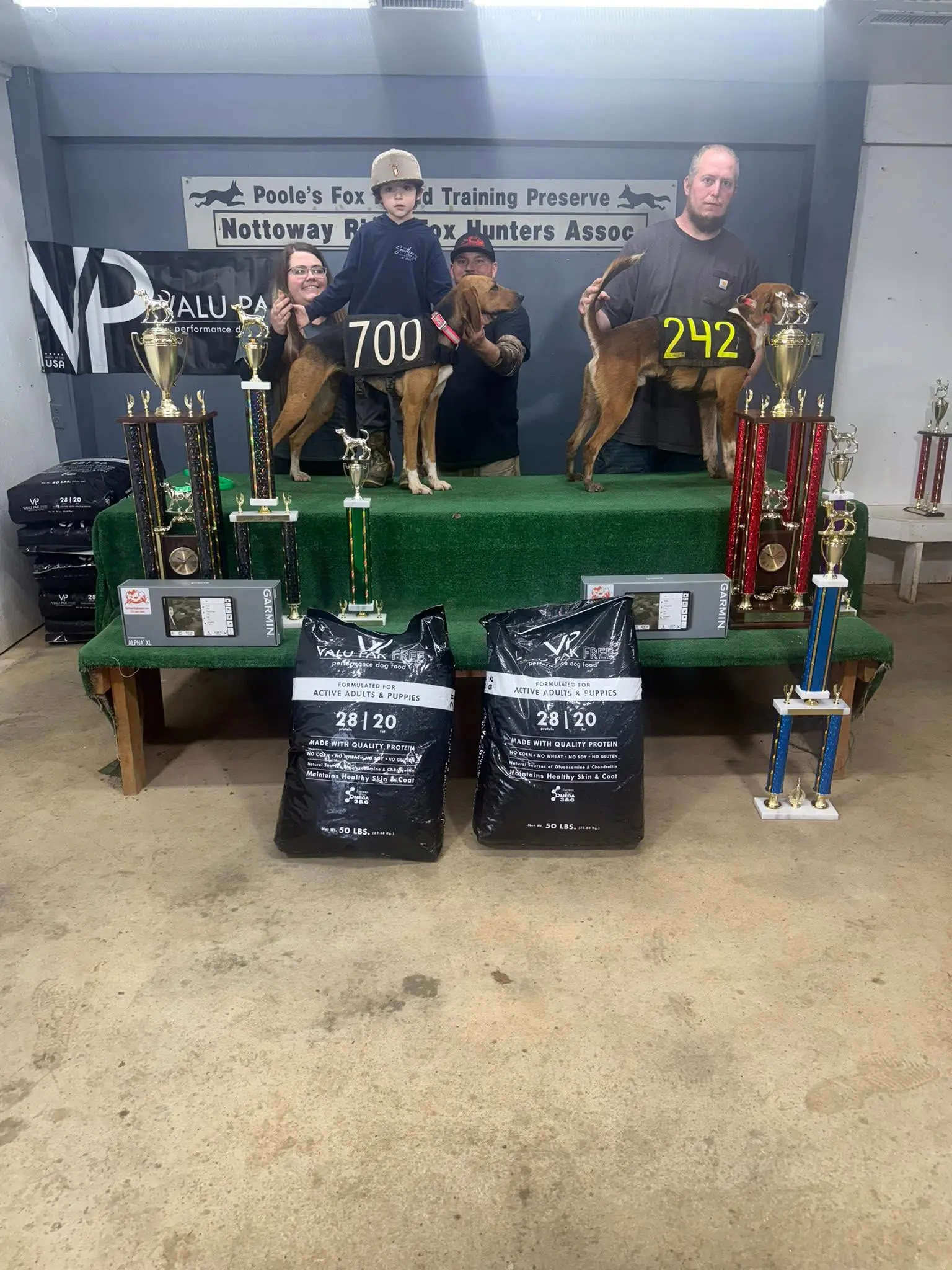 People with dogs and trophies on display.