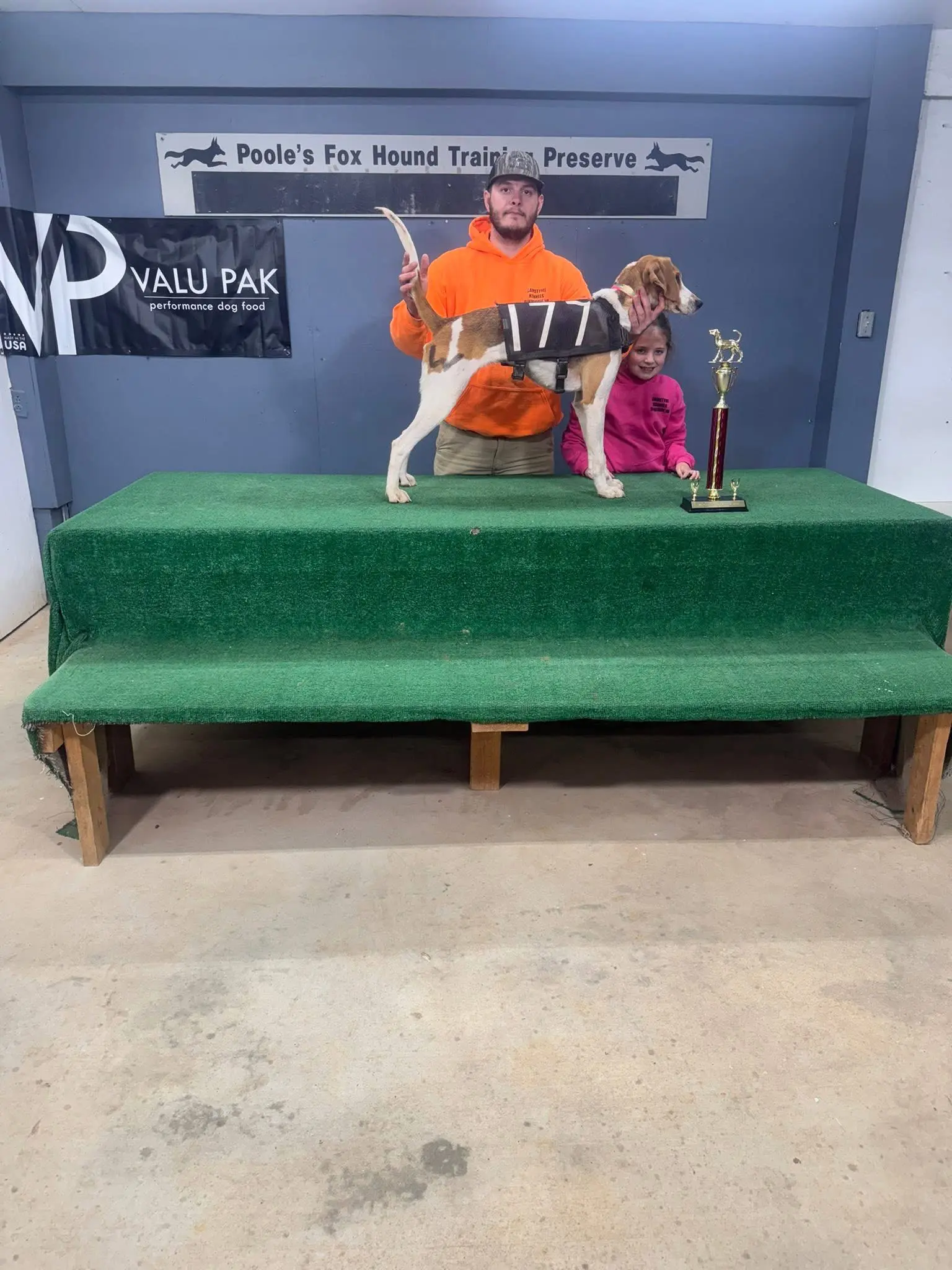 Man and child with dog and trophy.