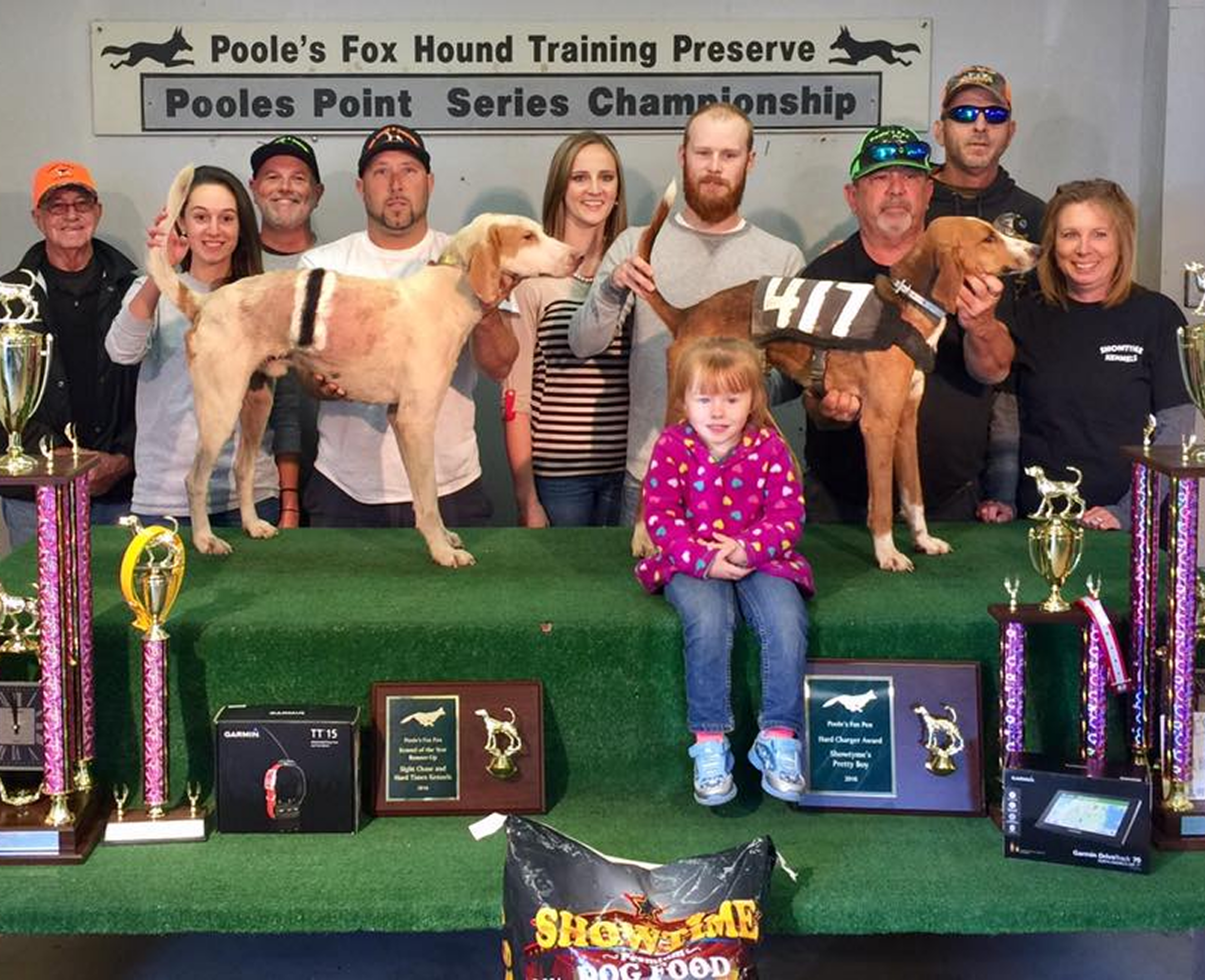 Dog show winners with their trophies and hounds.