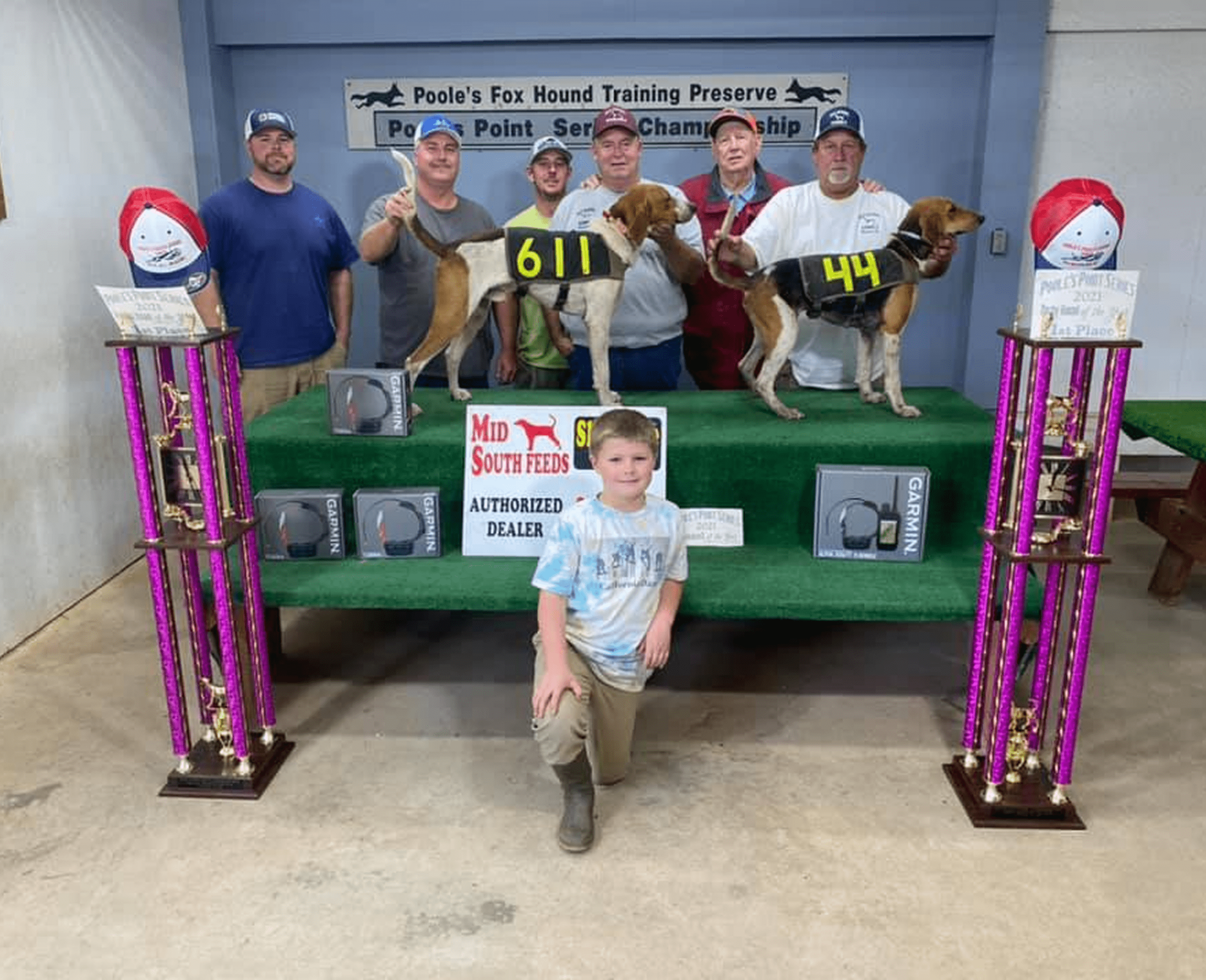People with hunting dogs and trophies indoors.